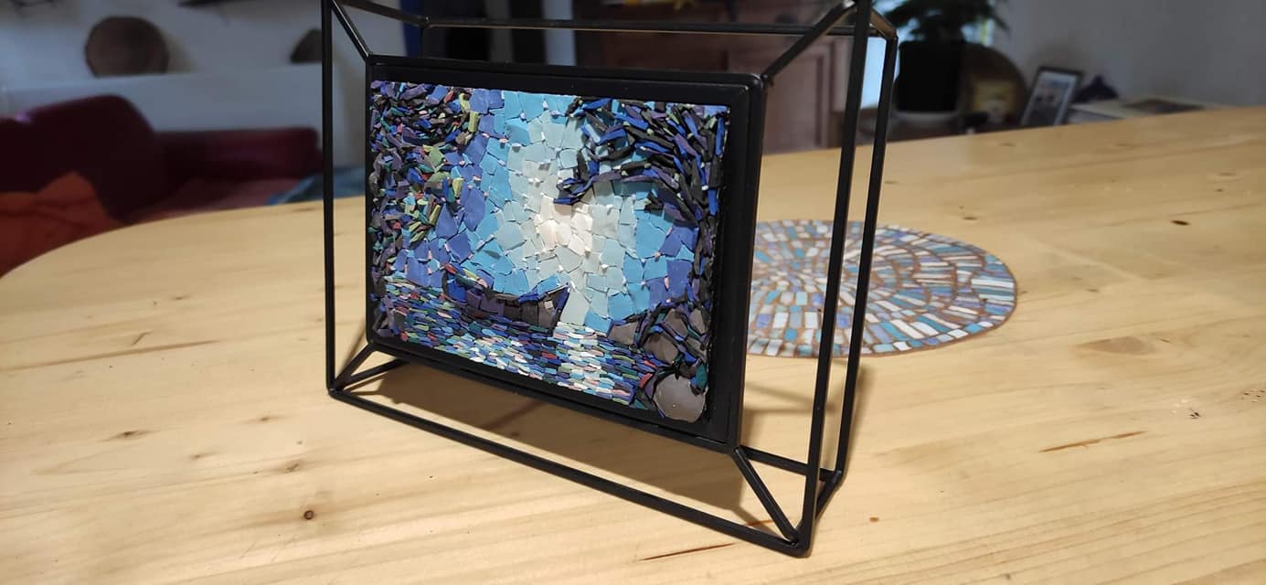 Cadre format photo représentant une barque sur l'eau dans la pénombre en mosaïque